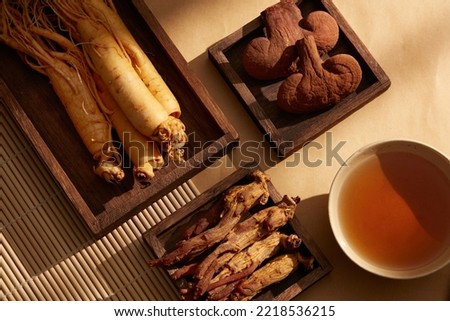 A wooden trays with bowls of medication, ginseng, red ginseng and reishi mushrooms. Traditional medicine. Royalty-Free Stock Photo #2218536215