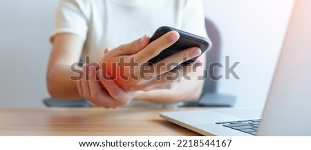 Woman having wrist pain when using mobile phone during working long time on workplace. De Quervain s tenosynovitis, ergonomic, Carpal Tunnel Syndrome or Office syndrome concept Royalty-Free Stock Photo #2218544167