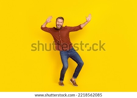 Full body photo of satisfied cool person raise hands enjoy clubbing isolated on yellow color background