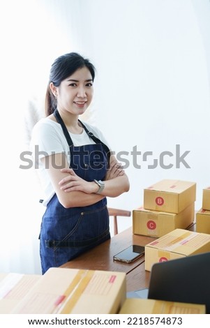 Starting small business entrepreneur of independent Asian woman smiling using tablet computer with cheerful success of online marketing package box items and SME delivery concept.
