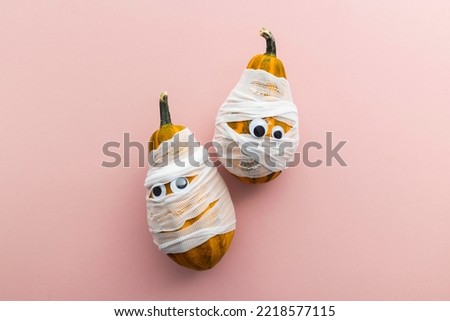Hallowwen holiday background concept. Gourd pumpkins dressed as scary mummies with bandages and eyes