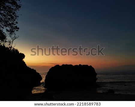 beautiful sunset on the beach, slightly covered with beach rocks