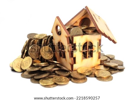 a wooden house and a bunch of metal Russian rubles as an illustration of mortgage lending