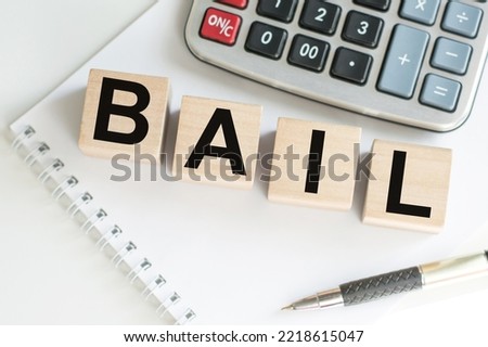 word BAIL on wooden cubes on blue background. the inscription on the cubes is reflected from the surface. business concept Royalty-Free Stock Photo #2218615047