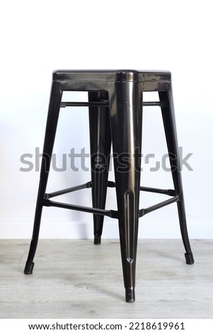 A studio lifestyle photo of a metal black bar stool