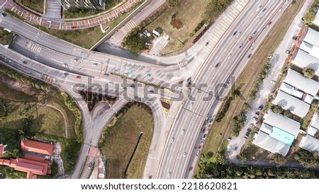 Aerial view directly above a six lane highway. Top view of asphalt road passes through the field and forest. Aerial. Sedan cars driving by the highway. Top view from drone. aerial photo autobahn road Royalty-Free Stock Photo #2218620821