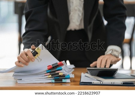 Close-up hand of Asian businesswoman arranging documents on her desk