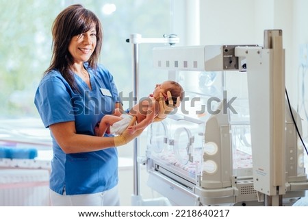 Health care concept. Doctor pediatrician holding newborn infant baby girl in hospital. Medical checkup. Royalty-Free Stock Photo #2218640217