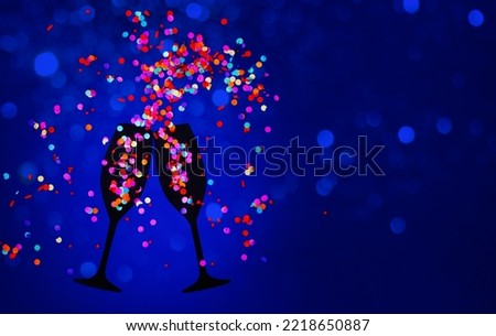Silhouettes of two glasses of champagne toasting made of cut cardboard and confetti simulating the splash and bubbles. Concept of celebration party