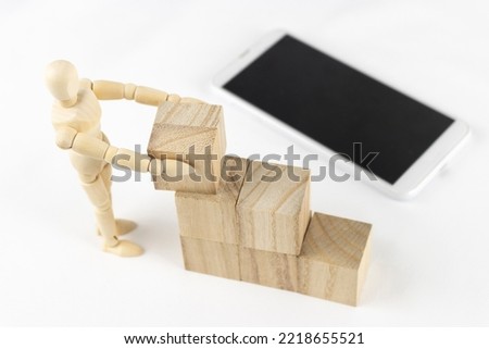 A wooden block, a drawing doll, and a smartphone. Image of work automation