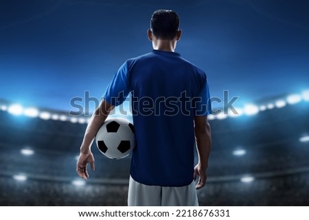 Soccer player holding ball in the stadium Royalty-Free Stock Photo #2218676331
