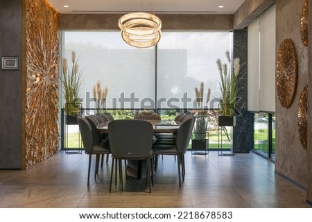 Roller blinds in the interior. Automatic solar shades large size on the windows. Modern interior with wood decor panels on walls. Plants in hi-tech flower pots. Electric sunscreen curtains for home.  Royalty-Free Stock Photo #2218678583
