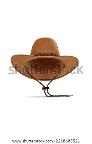 Close-up shot of a light brown wide-brimmed cowboy hat with a chin strap. The men's cowboy hat is isolated on a white background. Front view. Royalty-Free Stock Photo #2218685521