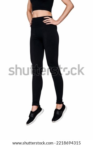 slim female legs in black sport leggings jumping