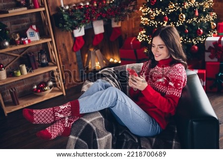 Full size photo of attractive cheerful person sitting chair use telephone festive miracle house indoors