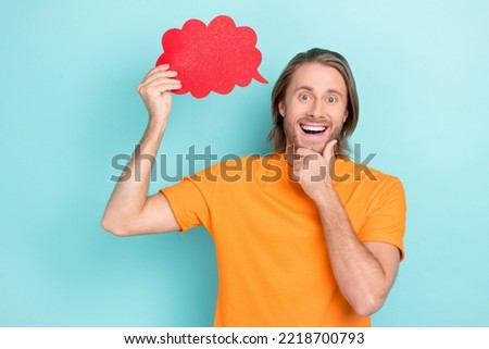 Photo of positive excited man wear orange t-shirt arm chin rising mind cloud empty space isolated turquoise color background
