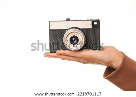 Close up of woman hand holding old vintage film camera over white background.