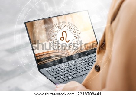 Astrological forecast for the zodiac sign leo. Woman holding an open laptop with a picture of a book and the zodiac circle. future prediction