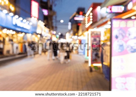 Blurred view of Seoul street with modern buildings, pavements and stylish people walking. Can be used as background. De focused image of capital of south Korea at night