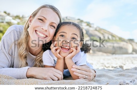 Mom, beach and girl lying for portrait with love, smile or happy for adoption, outdoor or sunshine. Woman, mother and child on blanket at ocean, sand or sea on holiday, vacation or family in summer
