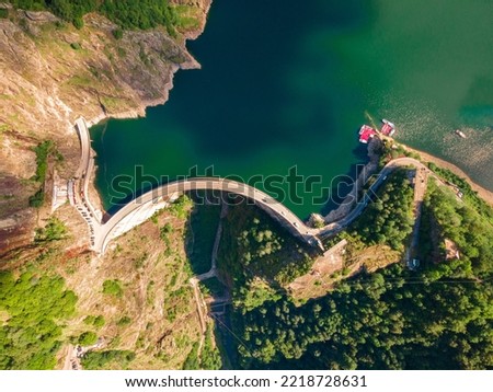 Aerial photography of Vidraru dam, in Romania. Photography was shot from a drone from above  the dam at Vidraru lake with the camera tilted straight down for a top view shot at the lake and dam.