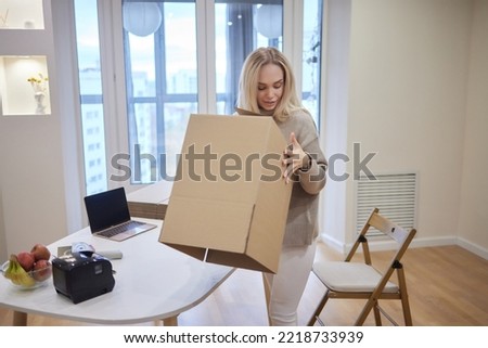 young blonde woman barcode printer and boxes on the background for market places.