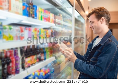 An European man but a bottle of mineral water from refrigerator cold in onvenience store for drink at home Royalty-Free Stock Photo #2218734615