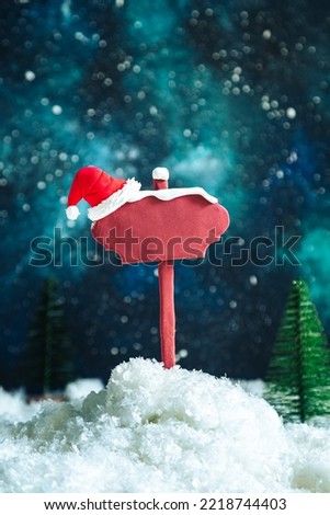 Wooden pointer and Santa's hat on the background of the night starry sky. Space for text, mockup, blank. Christmas background. 