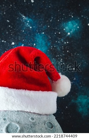 Santa's hat on the moon against the background of the night starry sky. Christmas background.