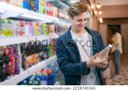 An European man but a bottle of mineral water from refrigerator cold in onvenience store for drink at home Royalty-Free Stock Photo #2218745565