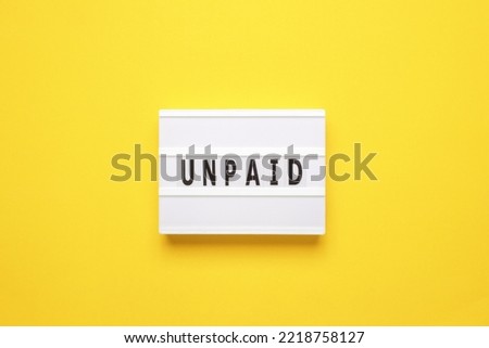 Lightbox with word unpaid on yellow background. Business and finance concept