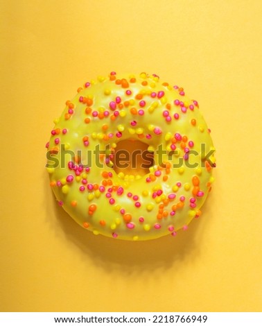 Top view of Mango donut with icing on pastel yellow background