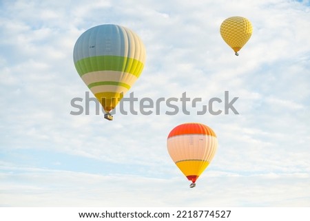 Three colorful hot air ballons flying in the air over Cappadocia, Turkey. Clear bright daytime sky. Tourist attraction. Horizontal shot. High quality photo