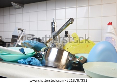 There is a lot of dirty dishes in the kitchen sink. Dirty dishes and unwashed kitchen appliances filled the kitchen sink. Royalty-Free Stock Photo #2218787331
