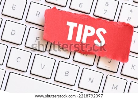 The word TIPS on a small red piece of paper lying on a computer keyboard. Royalty-Free Stock Photo #2218792097