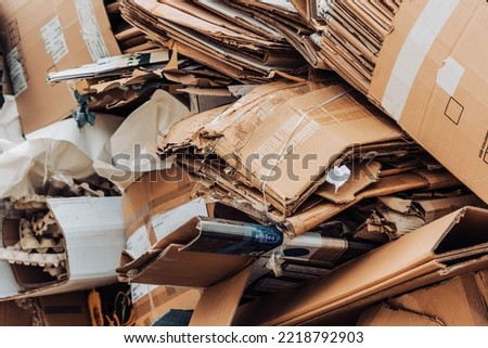 Cardboard waste pile stacked on a landfill. Recycled paper or reuse concept Royalty-Free Stock Photo #2218792903
