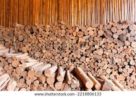 Stacked firewood eucalyptus wood logs and cut texture for rustic style background brown tones