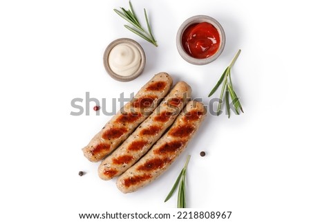 Grilled sausages isolated on white background with rosemary and sauces, top view, copy space. BBQ Royalty-Free Stock Photo #2218808967