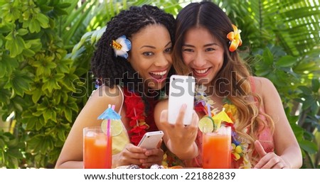 Two fun girls taking selfie on tropical vacation