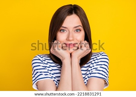 Photo of gorgeous pretty woman with straight hairstyle dressed striped t-shirt hold arms under chin isolated on yellow color background