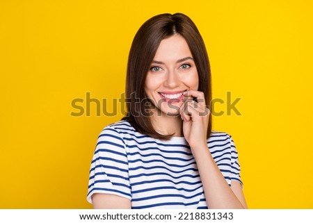 Photo portrait of pretty lovely young lady flirty bite finger smile treatment wear stylish striped look isolated on yellow color background