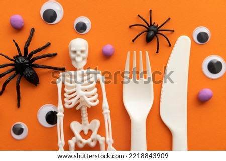 Cute children's halloween party background with cutlery, skeleton spiders and eyeballs