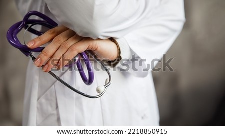 Doctor holding a stethoscope. on the background of blurred hospital corridor.