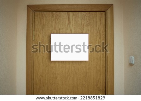 White empty nameplate with place for mock up mounted on wooden door of office entrance