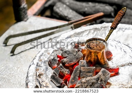 Cooking Turkish coffee on coals in traditional way. Close-up.