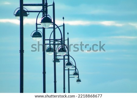 A series of public lighting lamps. Lampposts in a row. Royalty-Free Stock Photo #2218868677