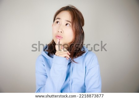 Asian woman with thinking gesture