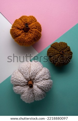 Knitted pumpkins on an colorful background, autumn composition.