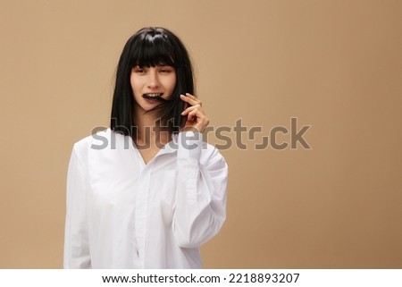 Happy enjoyed cute stylish adorable brunet lady in white shirt flirting smiling posing isolated on pastel beige studio background. Copy space Banner Offer. Pulp Fiction concept. Fashion Cinema