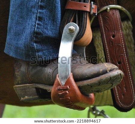 Western boots with spurs in stirrups or on ground
